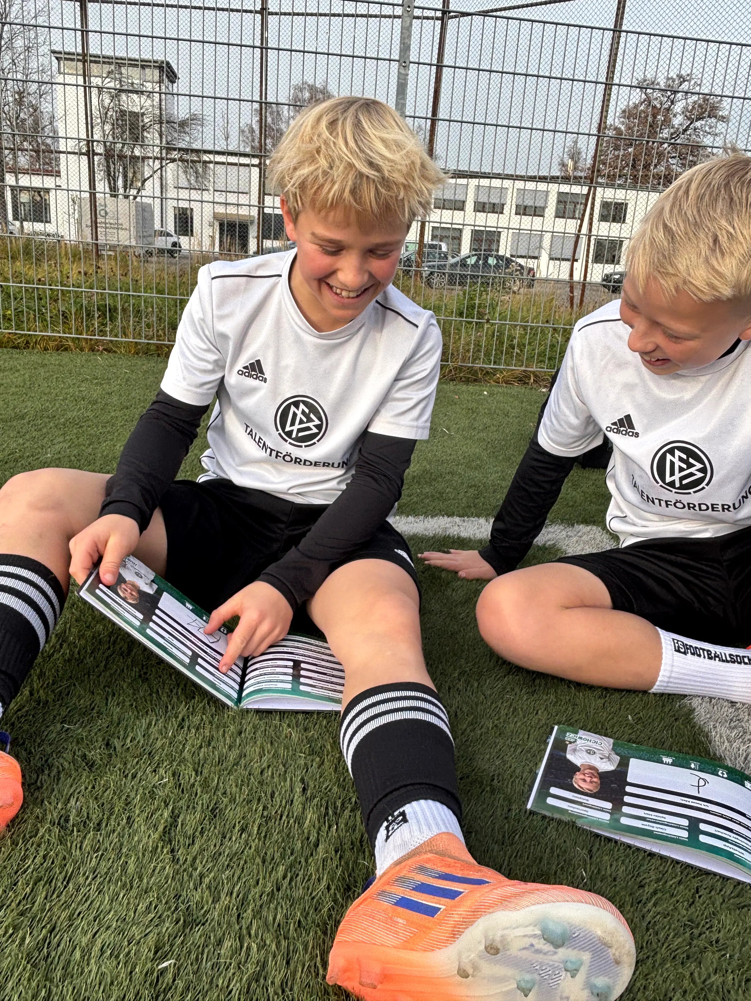 Junges Fußballteam umarmt sich nach dem Spiel – Flashbooks Team-Jahrbuch